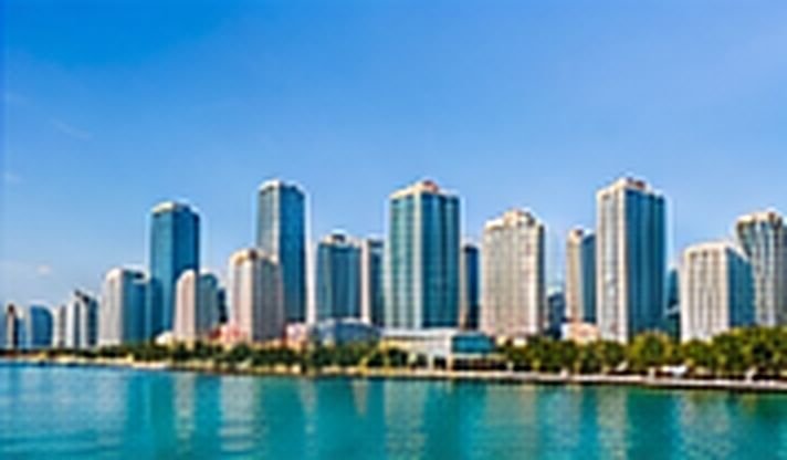 High-rise skyline across calm blue water